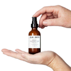 Hand holding a CLM DRYT bottle with a white background