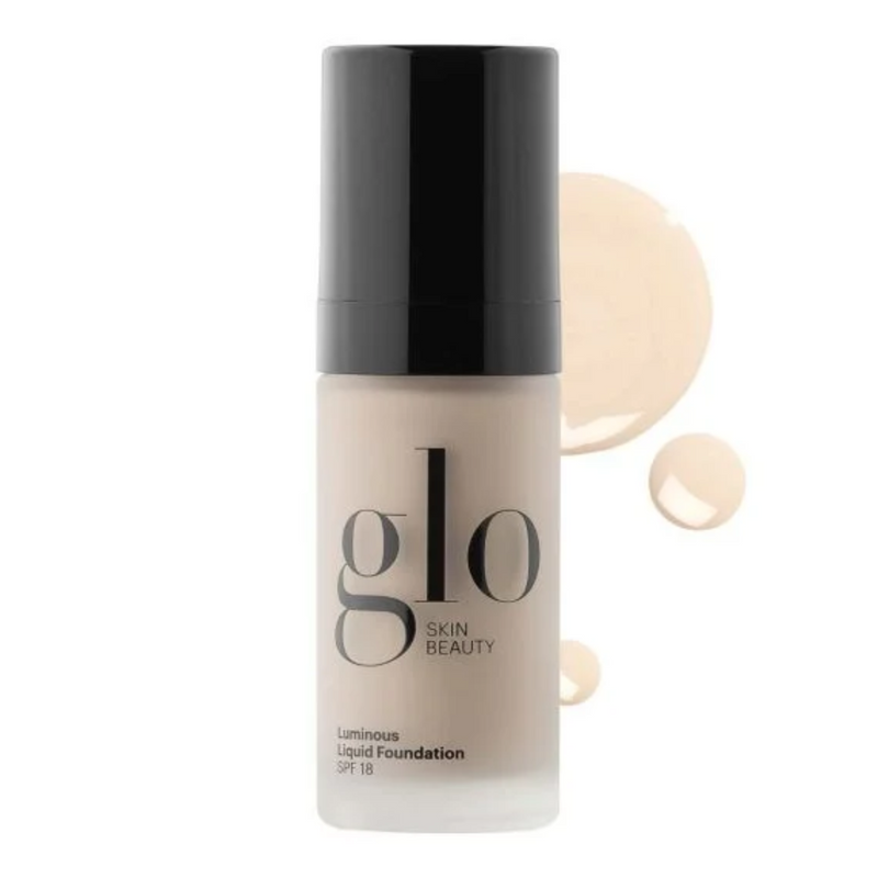 Glo Skin Beauty Luminous Liquid Foundation bottle with foundation sample on a white background
