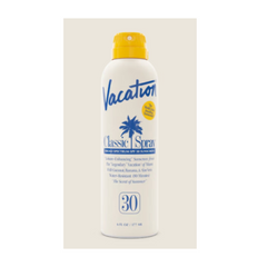 Vacation Classic Spray sunscreen bottle on a beige background