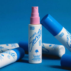 Super Sprite sunscreen bottles with pink and blue caps on a blue background